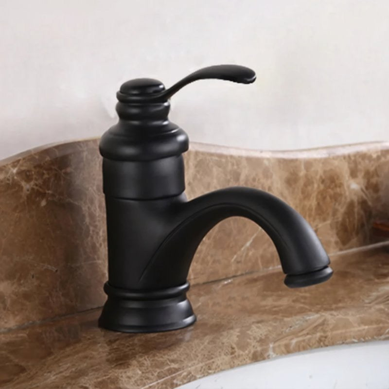 A black bathroom faucet with a curved handle is mounted on a marble countertop.